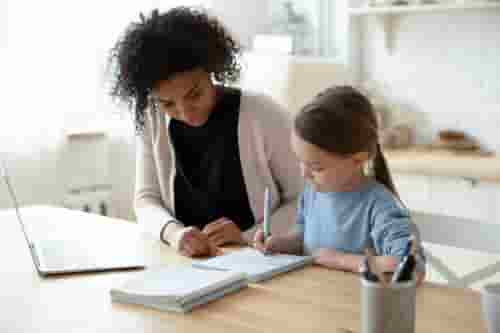 Nanny helping girl with homework